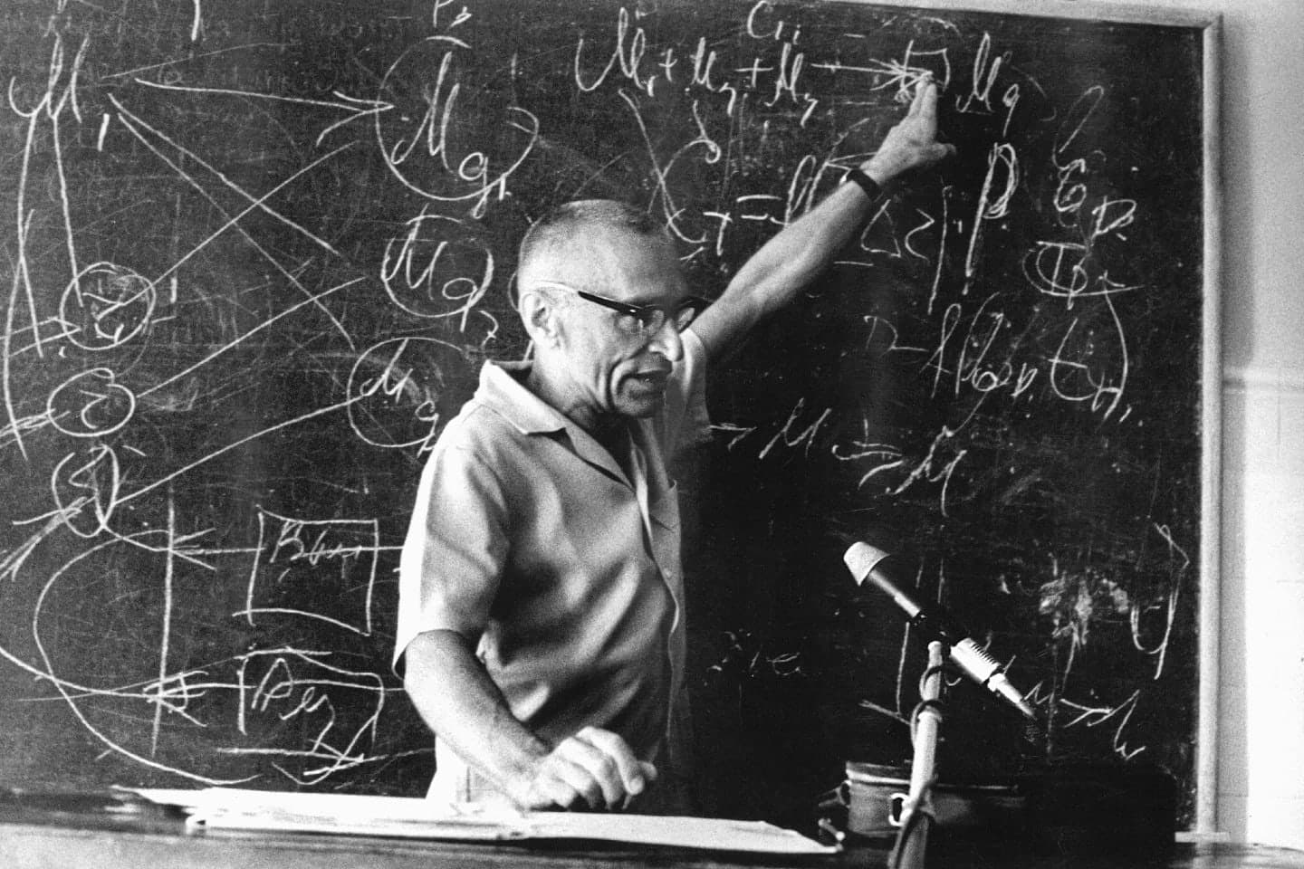 Mykola Amosov at a blackboard covered in formulas